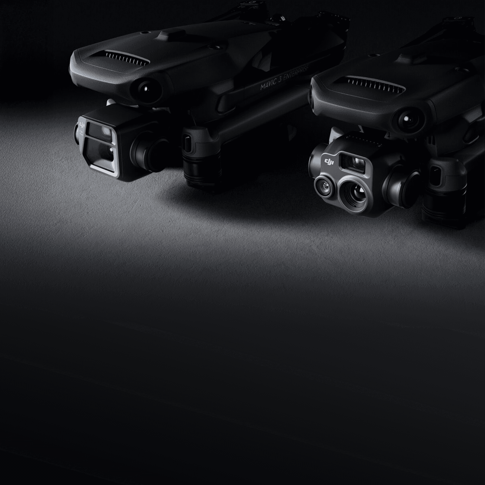 Två avancerade drönare med högteknologiska kameror visas i en mörk, minimalistisk miljö.