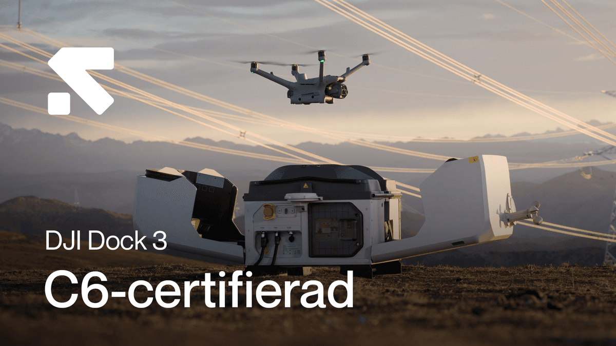 En drönare lyfter från en DJI Dock 3-station i ett öppet landskap, med kraftledningar i bakgrunden. en-dronare-lyfter.png