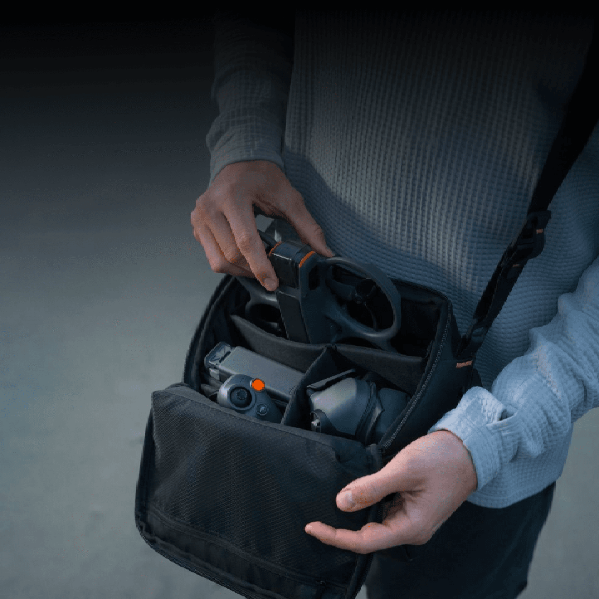 En person packar en drönare i en kompakt väska, redo för transport.