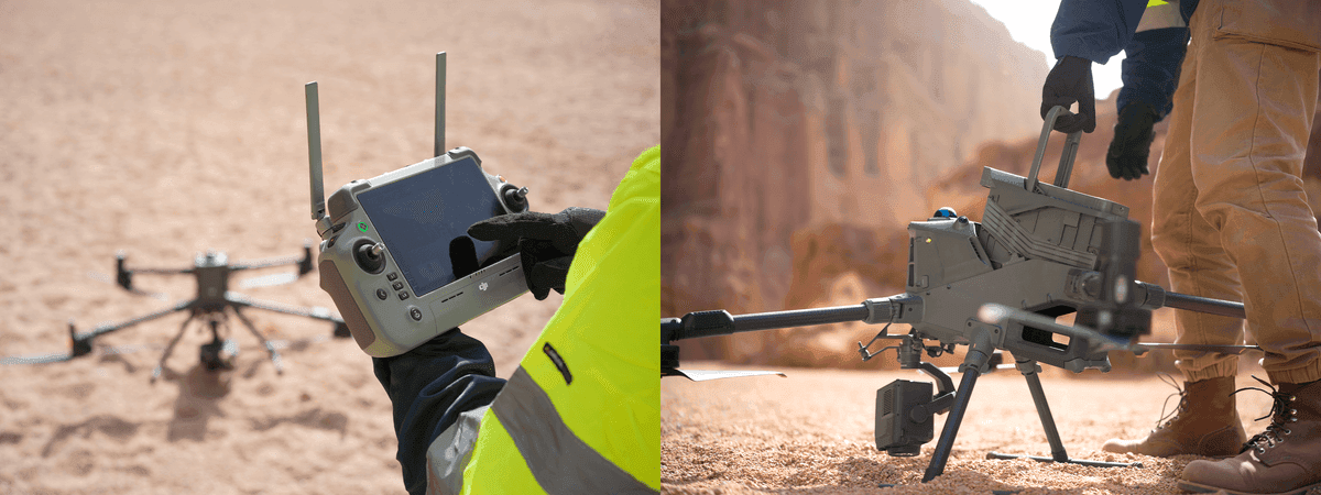 En person styr en DJI Matrice 400 med en fjärrkontroll i en ökenmiljö, medan en annan person förbereder drönaren för flygning på marken.
