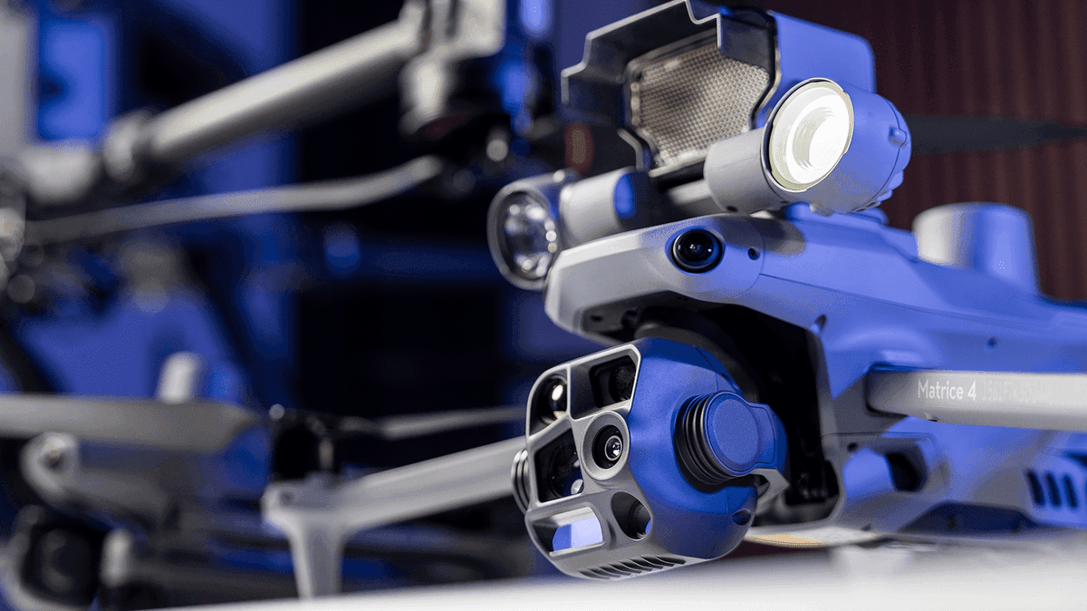 En avancerad drönare med flera sensorer och kameror visas i närbild, omgiven av en futuristisk, blåtonad miljö.