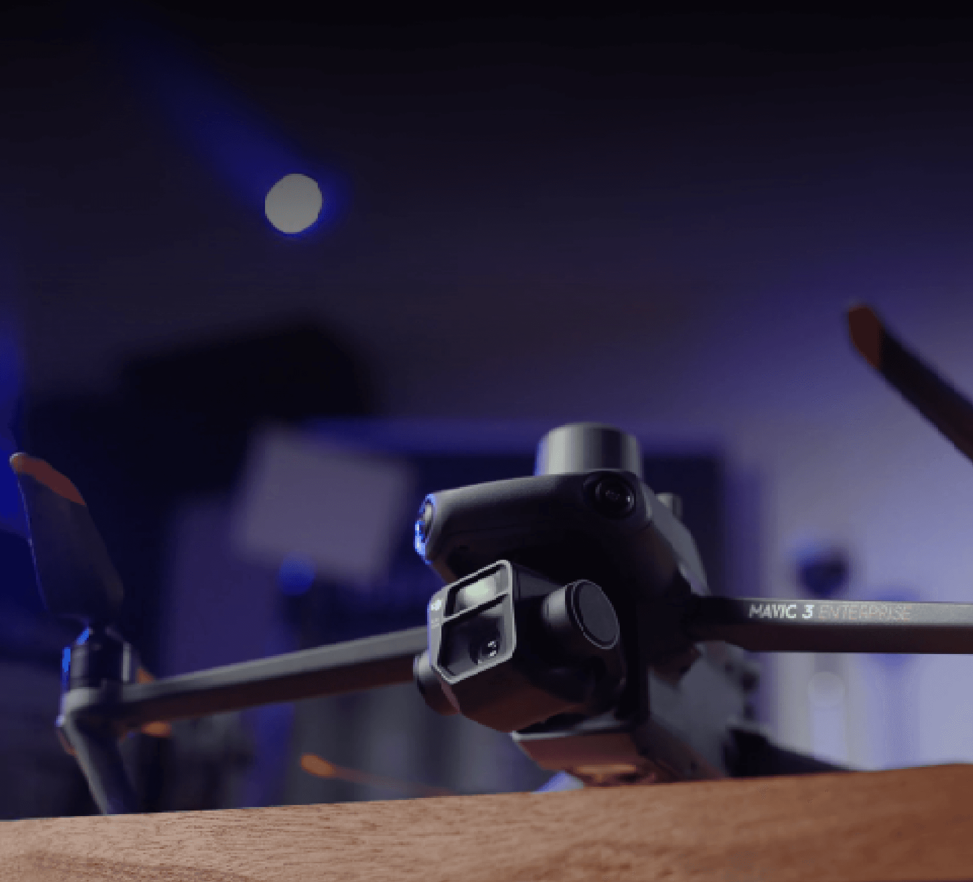 En drönare med avancerad kamera står på ett träbord i en dämpad, futuristisk miljö.