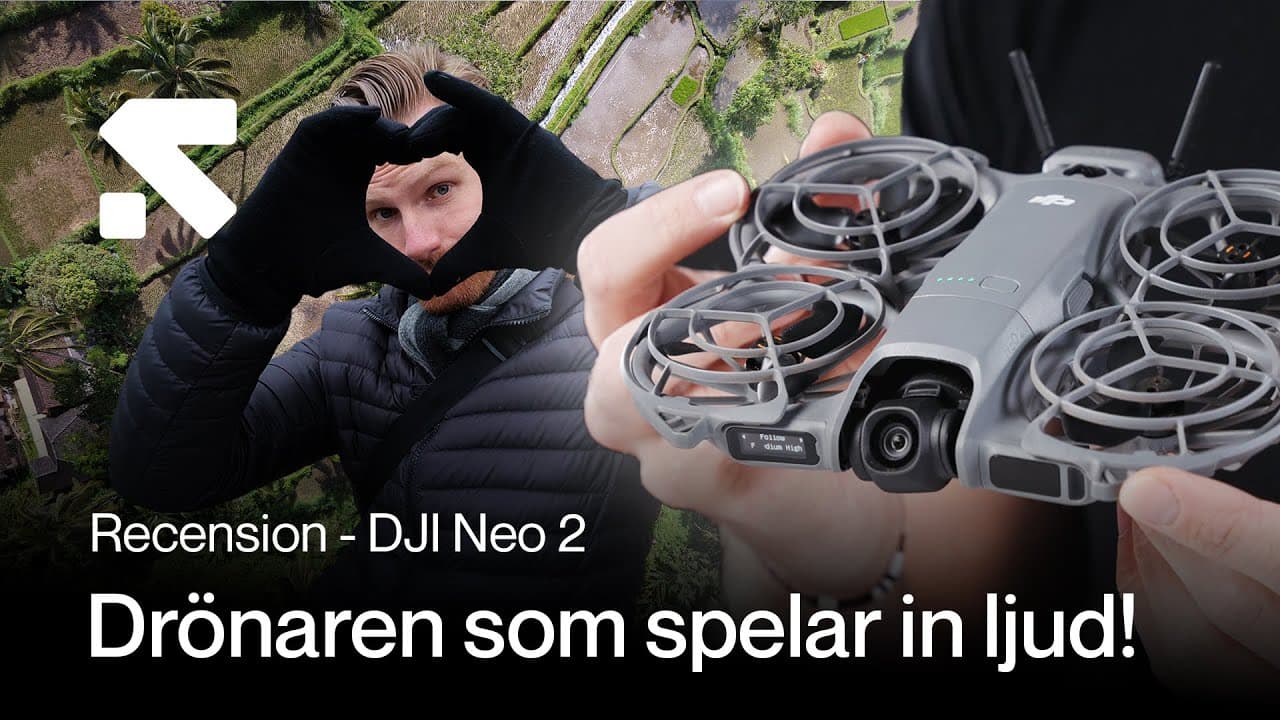 En person håller upp en DJI Neo 2-drönare framför en bakgrund av gröna fält. Texten på bilden nämner en recension av drönaren som kan spela in ljud.