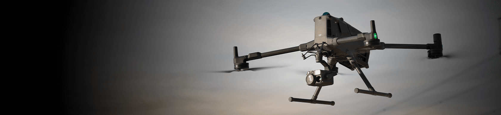 En drönare svävar i skymningen med en kamera monterad framtill, redo för inspektionsarbete.