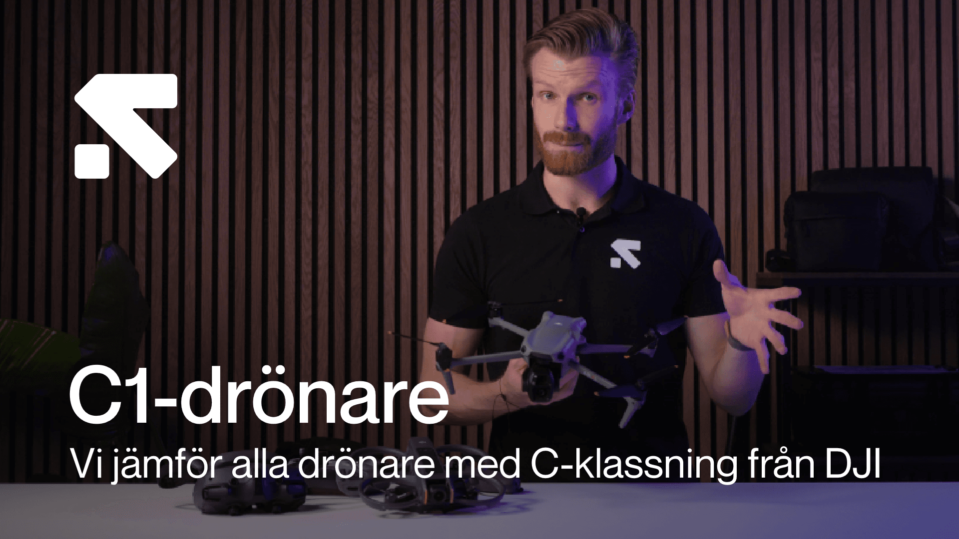 En person håller en drönare framför en träpanelvägg, med text som beskriver en jämförelse av C1-klassade drönare från DJI.