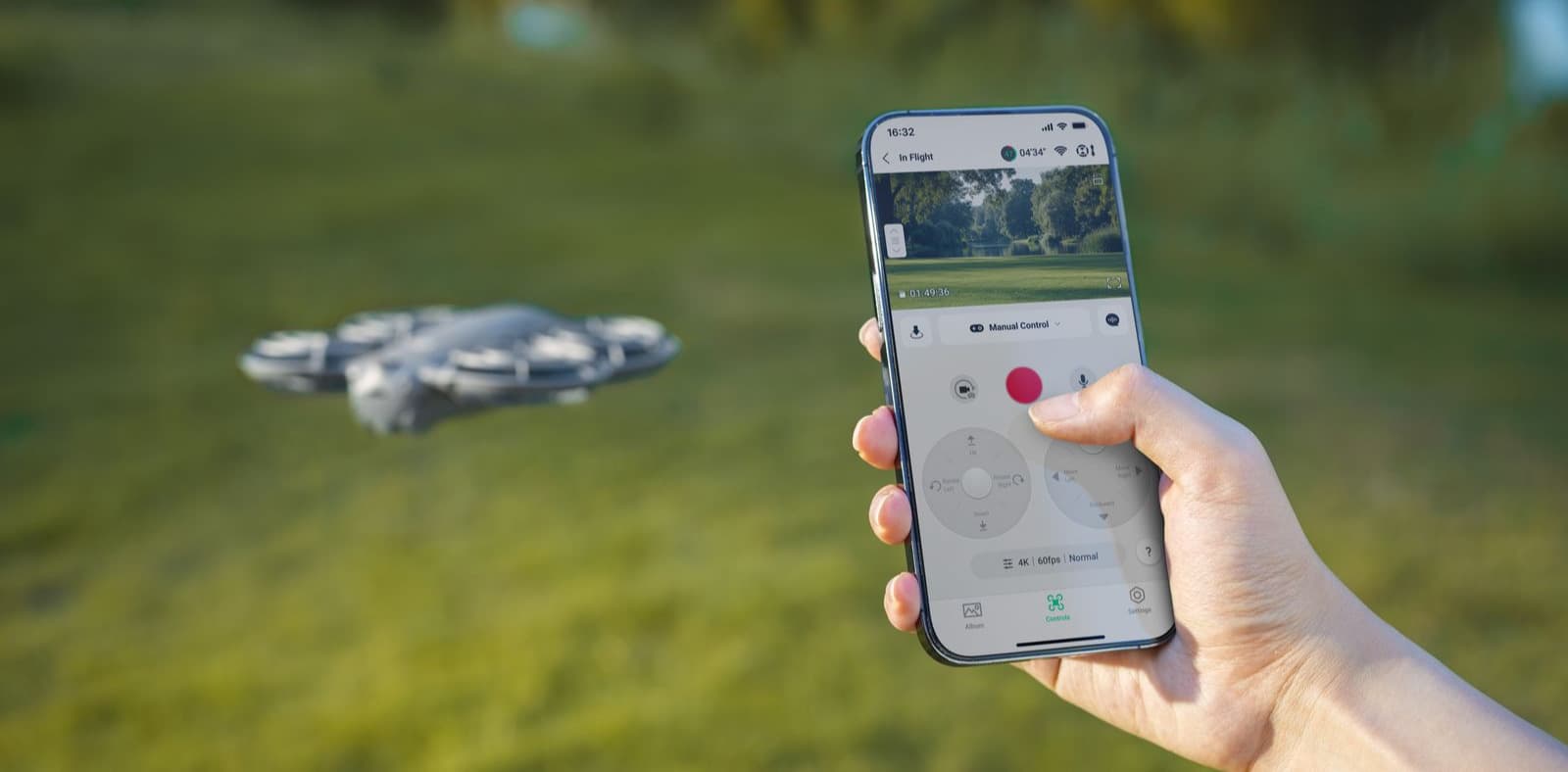 En person styr en DJI Neo 2-drönare med en smartphone i en grönskande utomhusmiljö.