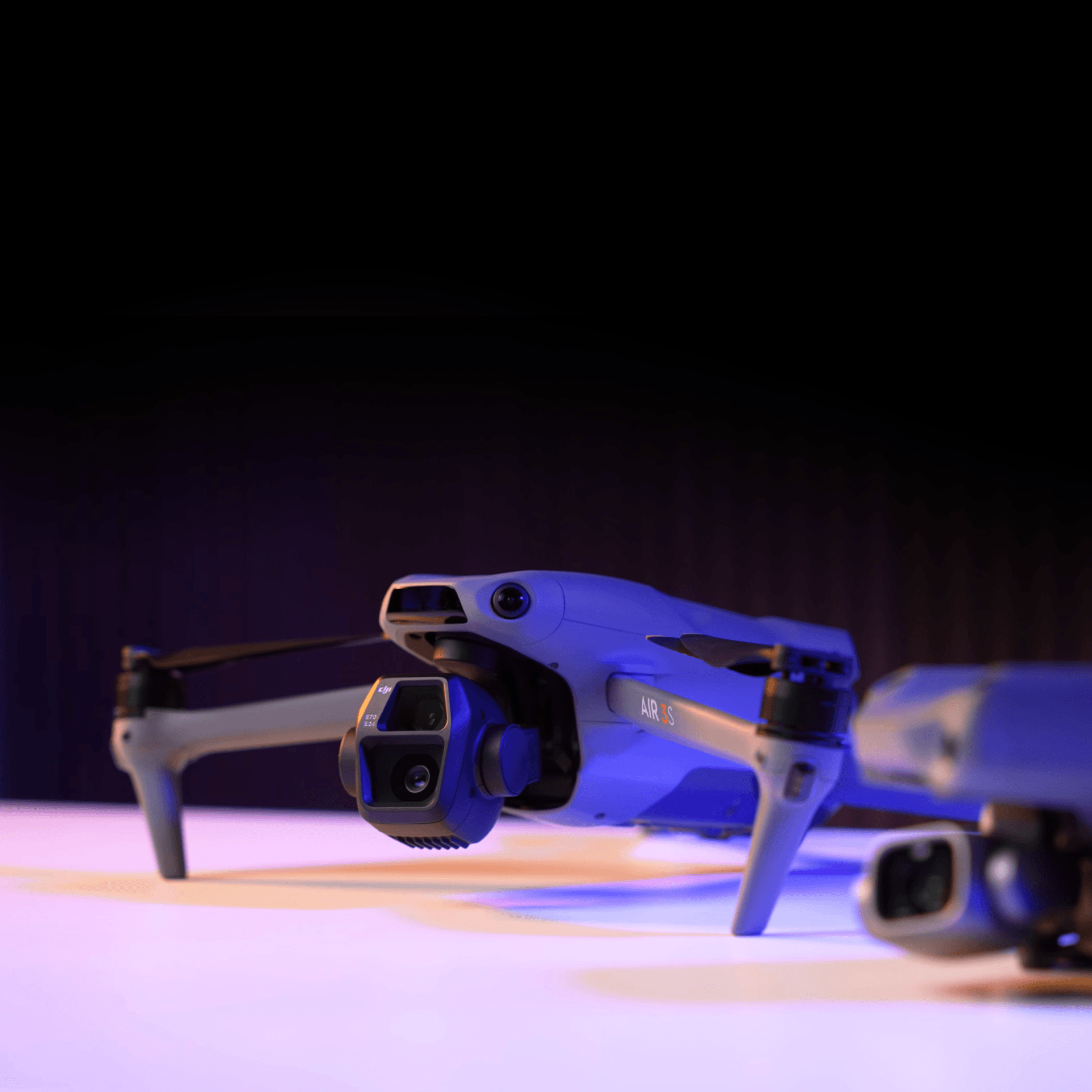 En populär drönare – en DJI Air 3S som presenteras på ett bord med blå belysning
