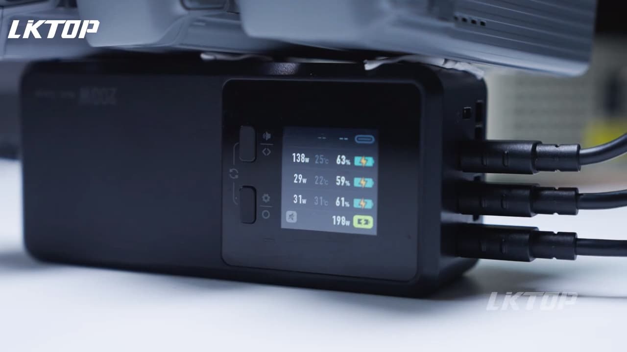 En svart elektronisk enhet med en digital skärm visar energiförbrukning och temperatur, med flera kablar anslutna.