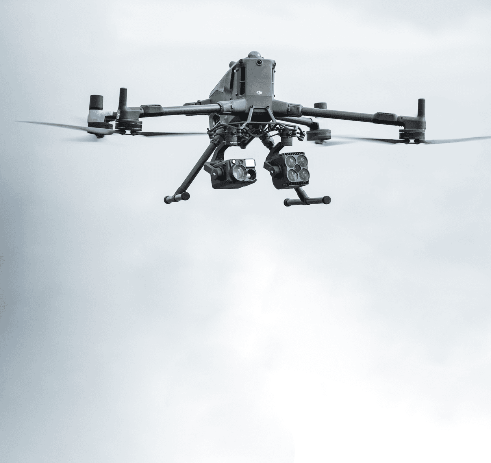 En DJI Matrice 400 svävar i luften, utrustad med flera sensorer och kameror för övervakning.