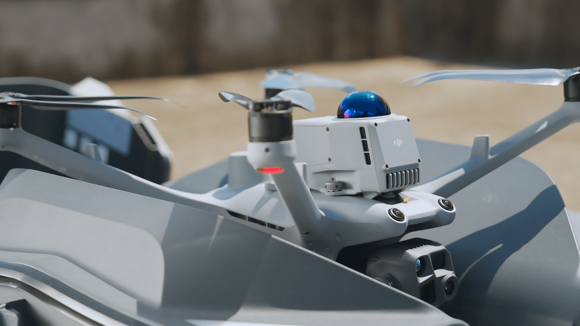 En avancerad drönare med flera rotorer och en kamera är redo för flygning på en solig dag.