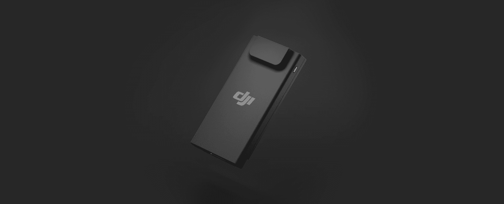 En svart DJI-enhet svävar mot en mörk bakgrund, med en minimalistisk och modern design.