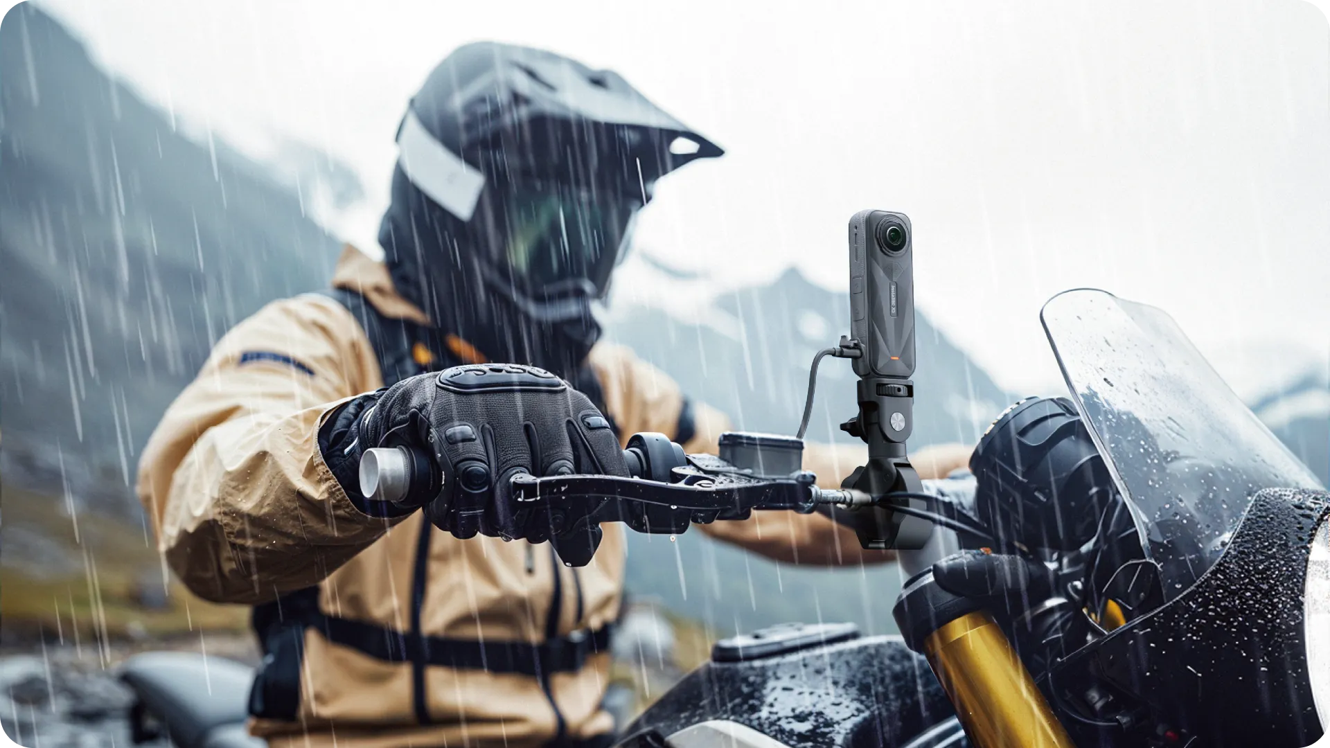 En motorcyklist i regnväder bär skyddsutrustning och kör genom ett bergigt landskap, med en actionkamera monterad på motorcykeln.